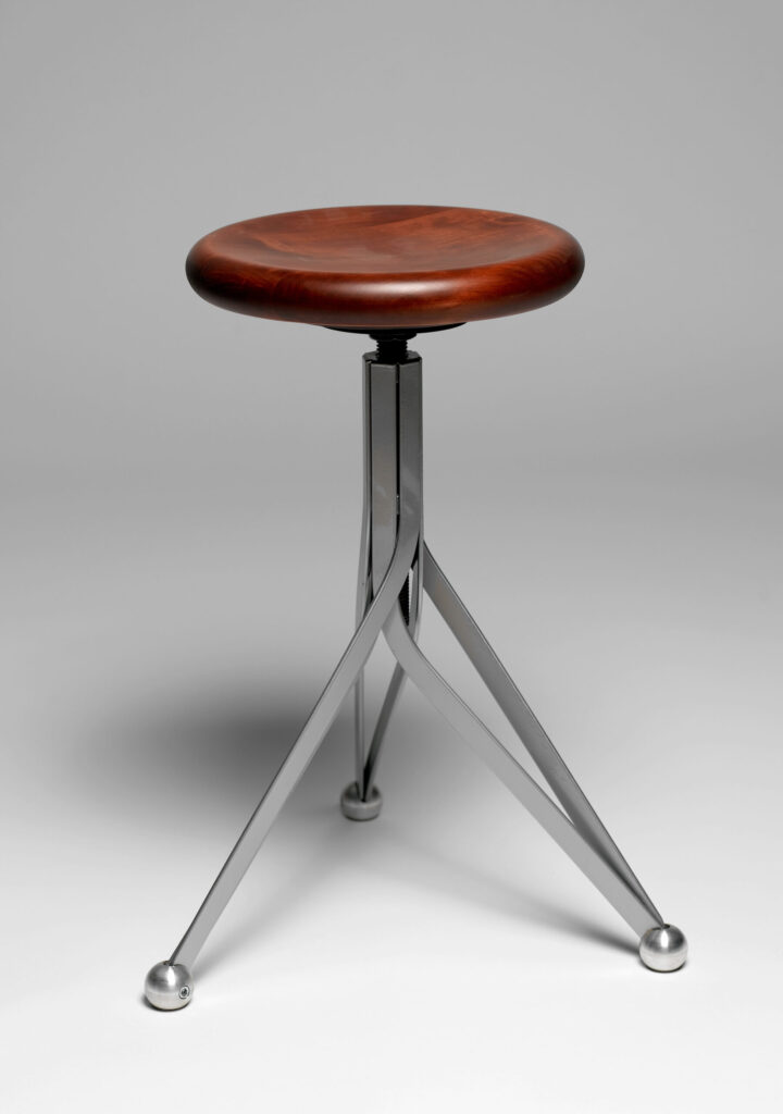 Tabouret avec un siège en bois et un pied en métal qui tourne sur lui-même